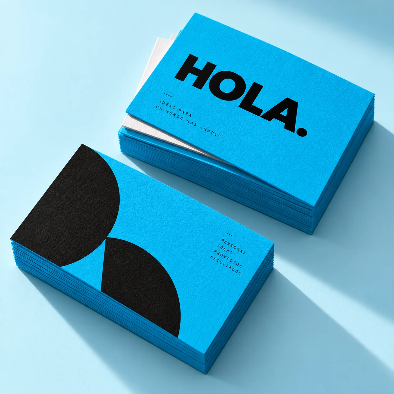 Muestra conceptual de tarjetas de presentación cian con tipografía y formas negras